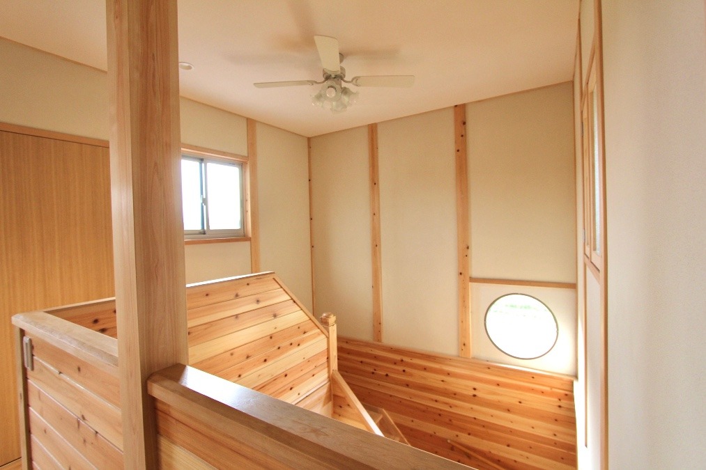 丸窓がアクセントの明るい階段スペース